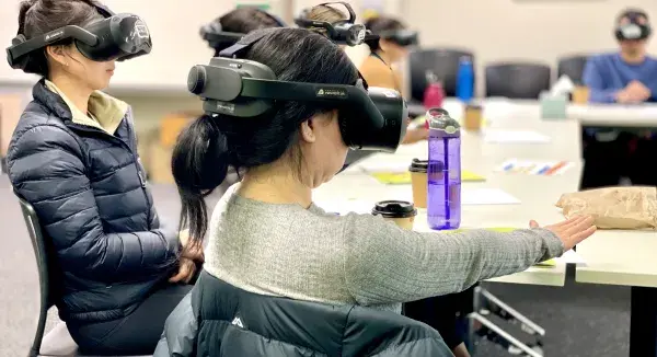 Staff members with virtual reality goggles on in a classroom setting