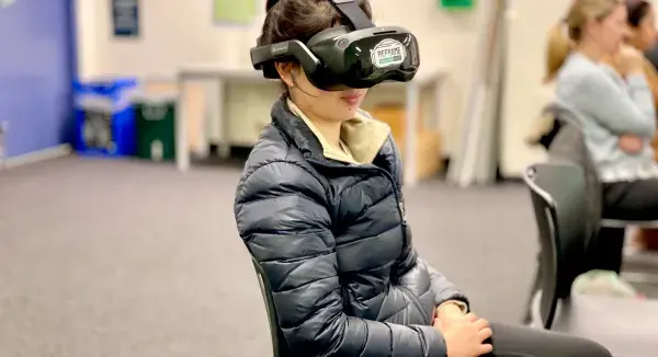 Staff members with virtual reality goggles on in a classroom setting