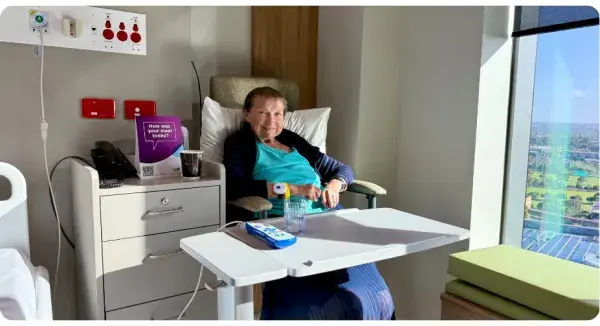 Woman sitting in bed with table across her lap.