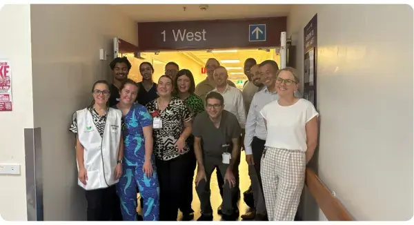 Staff in a hallway with 1 West sign above.