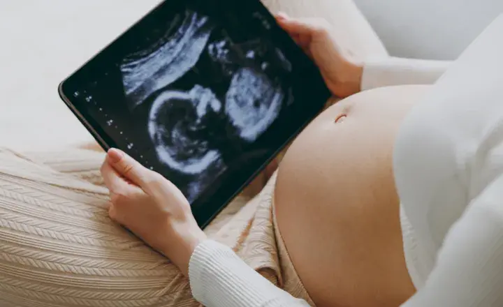 Pregnant women looking at a baby scan on an IPad