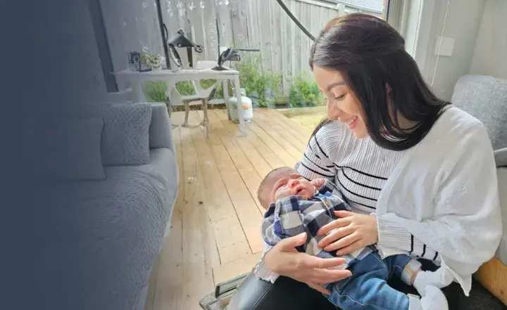 Mother holding a baby in a home. 